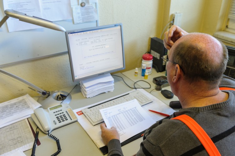 Wagenmeister Bernd Smuda bearbeitet Frachtpapiere am Computer